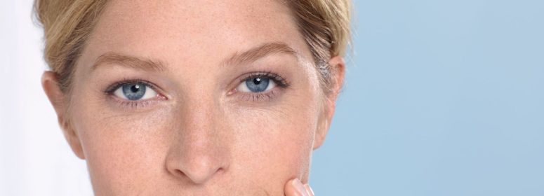 Женщина держится за лицо